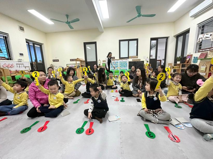 A group of children sitting on the floor with numbers

Description automatically generated